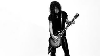 Slash playing guitar in black and white