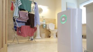 dehumidifier just inside bathroom with laundry drying on clothes rack