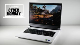 Dell G16 7630 gaming laptop on a white desk showing a game playing with a Cyber Monday deal banner in the upper-left corner