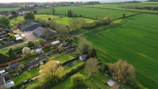 Gardens, agricultural land and potential infill plot show in a rural village setting