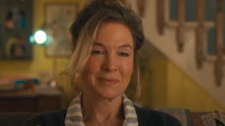 Renée Zellweger sits smiling in her living room in Bridget Jones: Mad About The Boy.