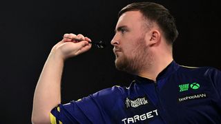 A side on shot of Luke Littler throwing a dart during the PDC World Darts Championship