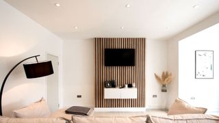 Contemporary home with slatted wooden feature wall and downlights on white ceiling