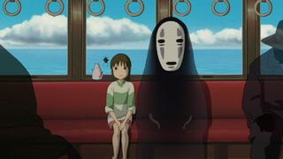 Best anime movies: Chihiro and No-Face sitting in a train carriage during Spirited Away.