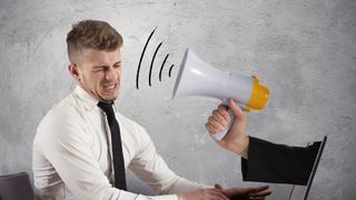 arm reaching outside laptop aiming blowhorn at man