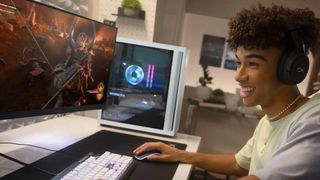 Press image showing the white HP OMEN 25L gaming desktop PC on a desk, with a young man in the foreground playing a PC gaming on a monitor while wearing a headset and using a mouse and keyboard.