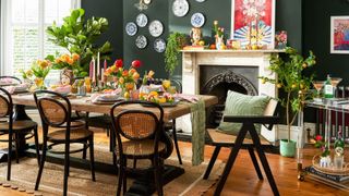 green dining room with wooden dining table and bistro chairs and glass drinks trolley