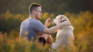 Man giving dog a treat using one of four expert-approved dog treat delivery methods