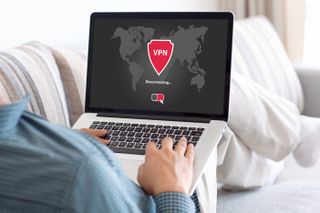 Man holding laptop with VPN app