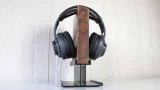 The Uplift Headphone Stand with a pair of open-ear headphones hanging from it