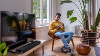 Harman Kardon Enchant 900 Dolby Atmos Soundbar in a living room in front of a TV