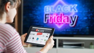 Woman holding tablet looking at Black Friday deals