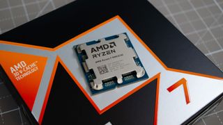 An AMD Ryzen 7 9800X3D on a desk on top of its retail packaging