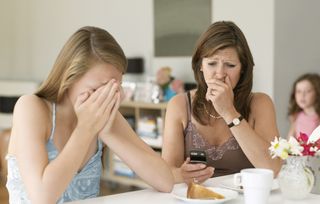 A woman and daughter upset at something on a phone