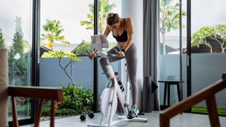 A woman riding one of the best exercise bikes at home