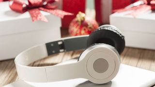 White headphones and laptop with Christmas presents in background