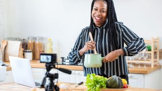 Woman in kitchen presenting cookery video on YouTube