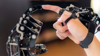 Asian boy is learning to control the robotic arm. 