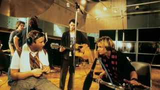 Phil Collins, Bob Geldof and Sting stand together during a Band Aid recording session