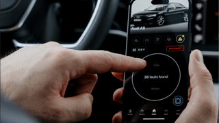 an image showing a person using the OBDeleven app to check their car diagnostic report for any faults