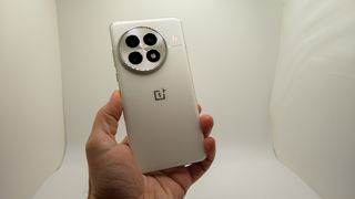 Holding the Arctic white OnePlus 13