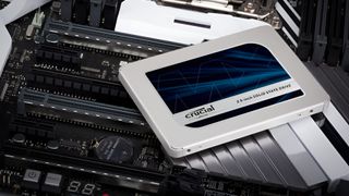 A promotional image of a Crucial MX500 SATA SSD resting on a computer motherboard