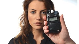 Best light meters - Sekonic light meter being used to measure exposure in a portrait studio