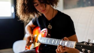 A young boy plays the electric guitar