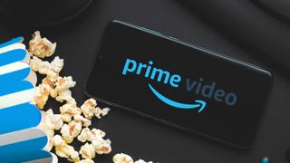 Prime Video app on a phone near popcorn and headphones