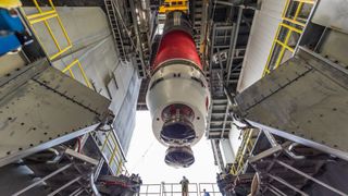 a rocket hangs suspended in an assembly hanger.