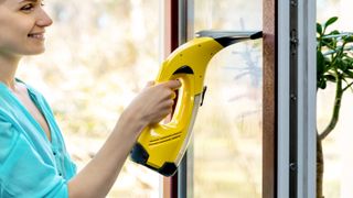 Woman removing condensation from a window