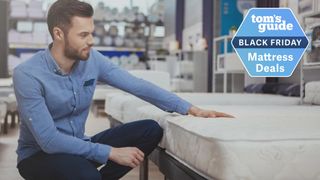 A man touching a mattress in a store