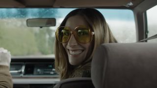 Sarah Levy&#039;s character smiling eerily into the camera inside a car in The Monkey