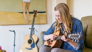 Female guitarist playing an acoustic guitar