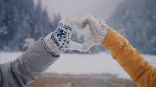 wearing gloves and making a heart shape with hands 