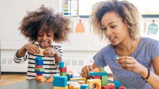 Mom and child playing with wooden blocks.