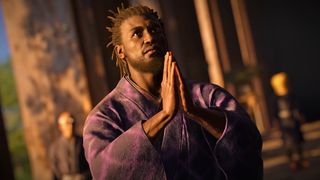 Assassin&#039;s Creed Shadows screenshot showing Yasuke kneeling and praying while wearing a traditional purple robe