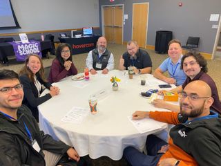 Eight attendees working at a round table 