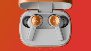 The B&amp;O Beoplay Eleven earphones on orange and red background