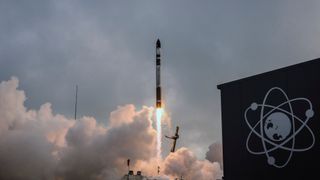 a black and white rocket launches into a cloudy sky