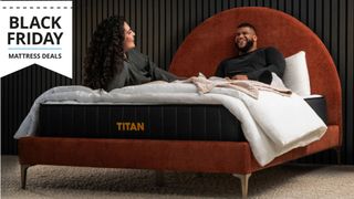 A couple sat on the Titan Plus bed laughing