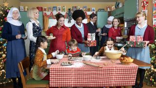 The cast of Call the Midwife stand around a table as the Turner children bake in the Call the Midwife Christmas special 2024.