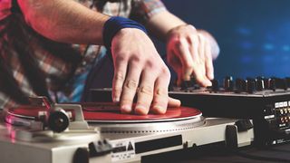 DJ with his hands on a mixer and vinyl turntable