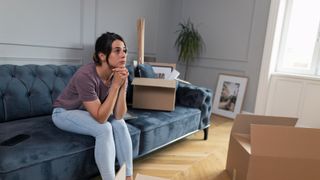 A woman sitting on a blue sofa looking worried