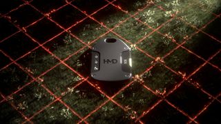 Photo of the HMD OffGrid satellite tool sitting on grass with a laser grid below it