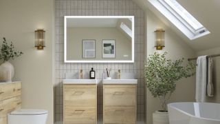 A modern light bathroom with a skylight and a light up mirror, two vanities and a standing bath