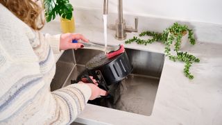 Cleaning air fryer in white kitchen