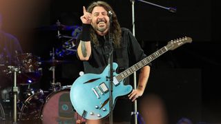 Dave Grohl performing with a blue guitar