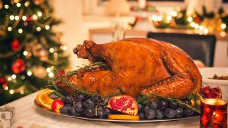 Roast turkey on dining table, with Christmas decorations in background