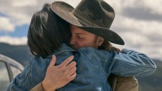 Monica (Kelsey Asbille) and Kayce (Luke Grimes) in a tearful embrace against the Montana skyline in Yellowstone Season 5.